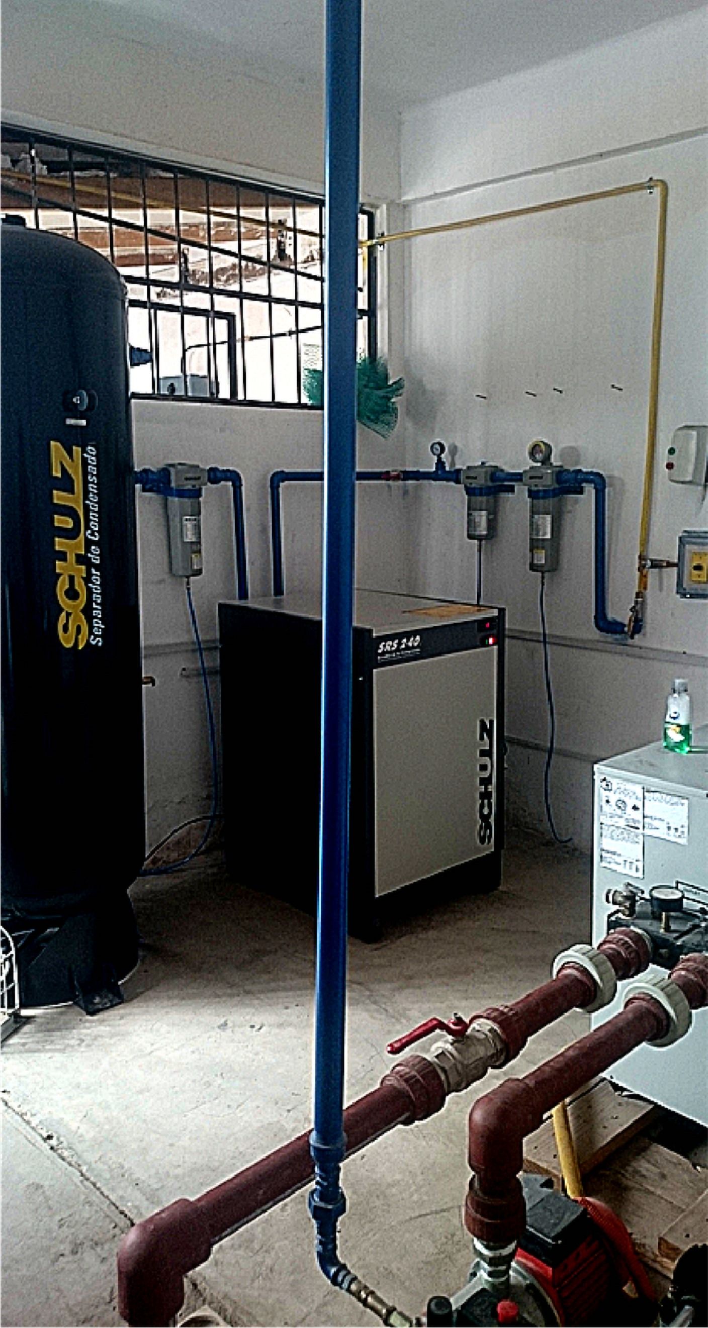 Compresor y tuberías azules y rojas en una sala