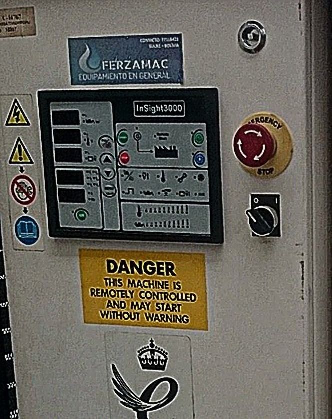 Panel de control con botón de emergencia y rótulo de advertencia