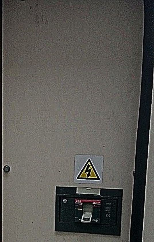 Panel gris con rótulo de advertencia y un interruptor