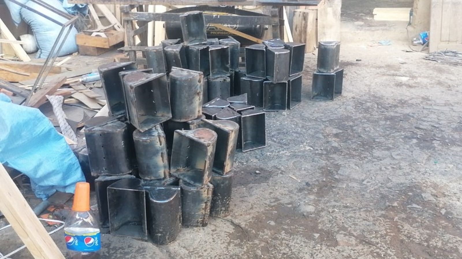 Bandejas metálicas oscuras sobre el suelo de un taller