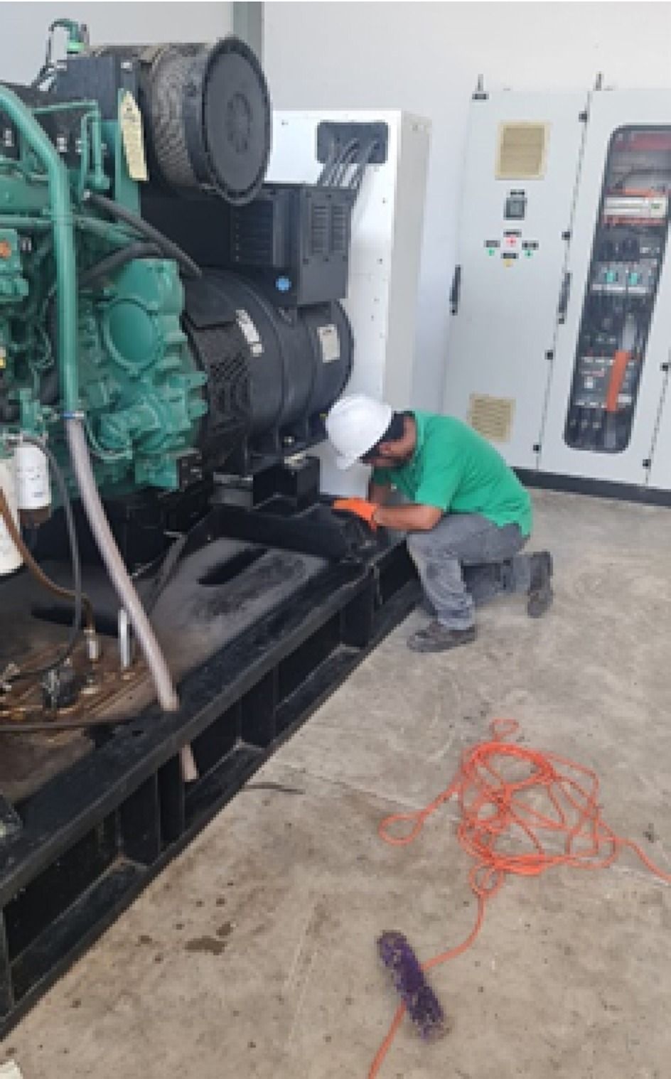 Técnico agachado junto a un grupo electrógeno