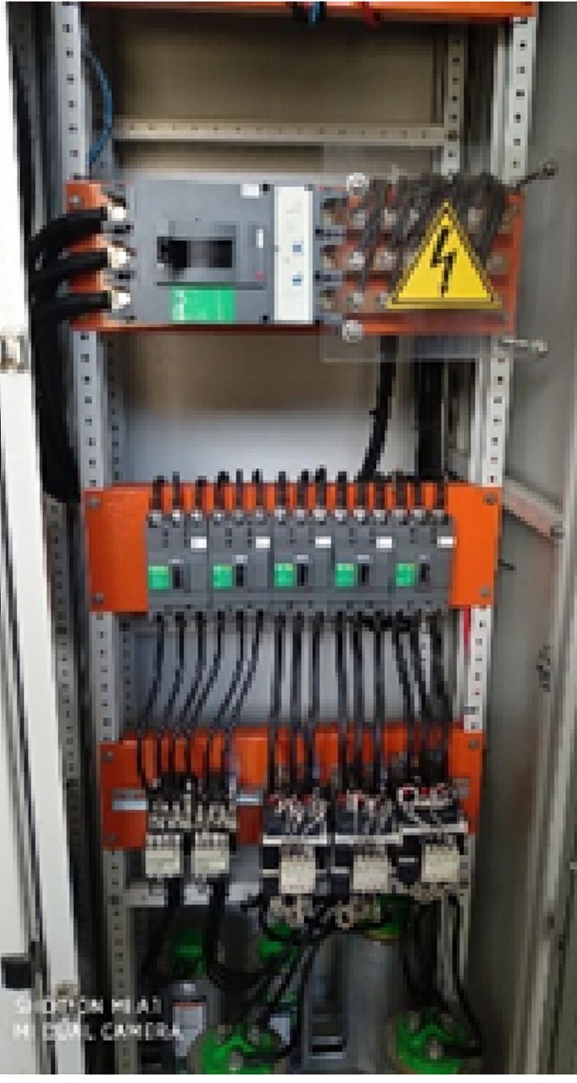 Tablero eléctrico abierto con interruptores y barras naranjas
