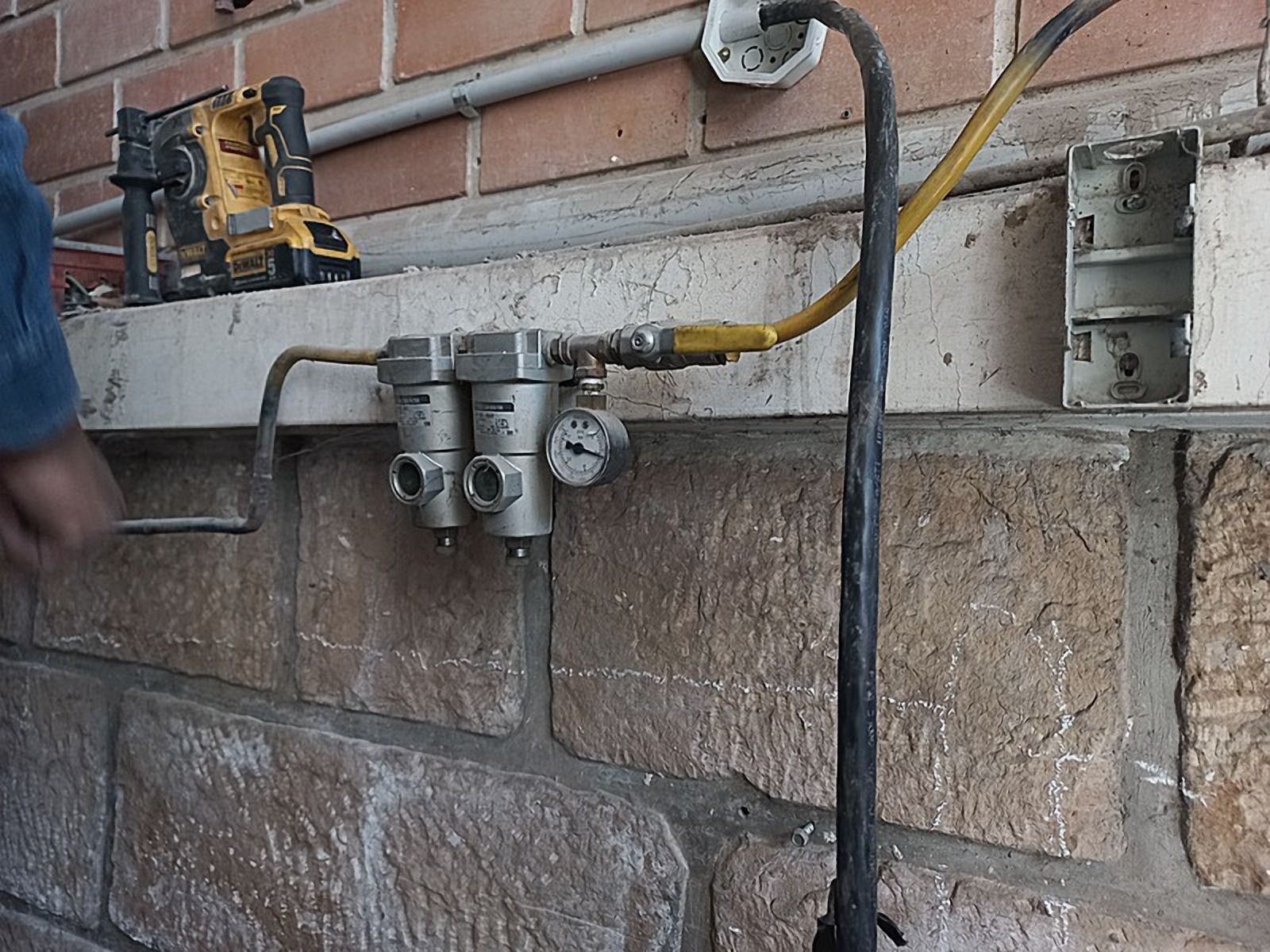 Válvulas y accesorios montados sobre una pared de ladrillo