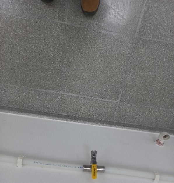 Accesorio metálico en una tubería bajo el cielo falso