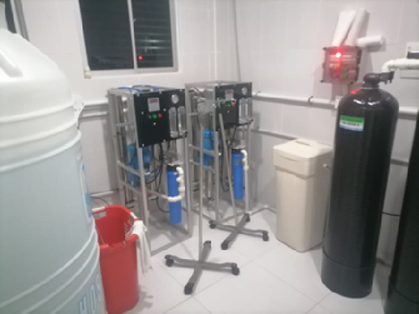 Equipo de tratamiento de agua sobre bastidor, con un tanque blanco y otro negro