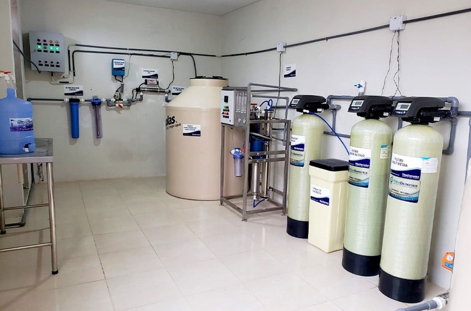 Sala con tanque de agua, equipo de tratamiento y tres tanques de filtros